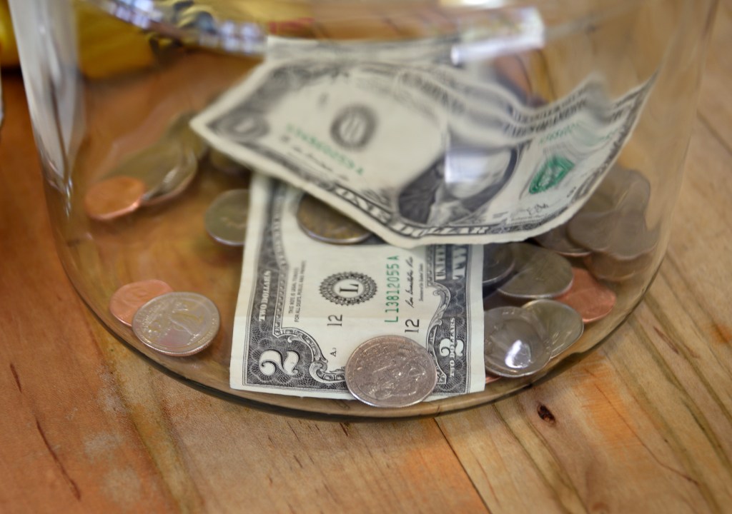 US dollars and coins in a tip jar