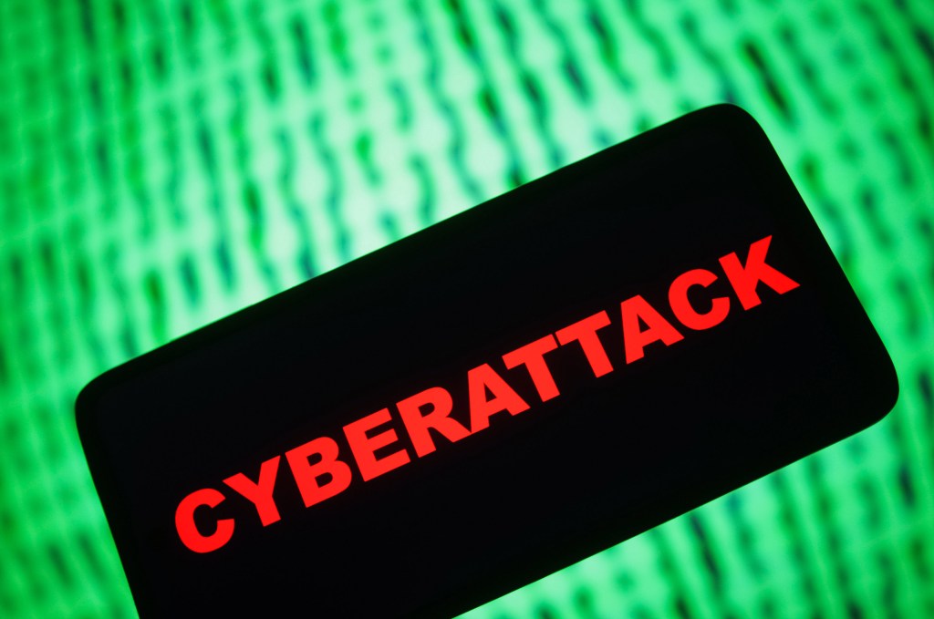 Cyberattack word written in red agains a green computer text background