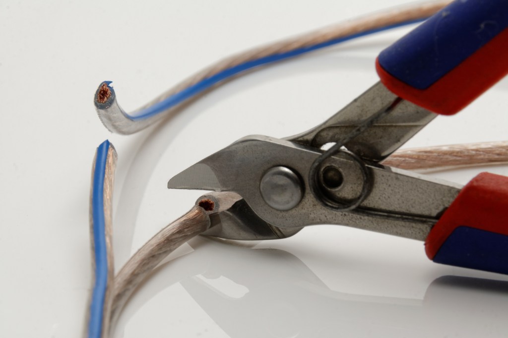 pliers snipping a wire that is already cut elsewhere